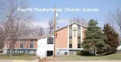 Exterior view of Homestead Presbytery church in Lincoln, with trees and clear sky.