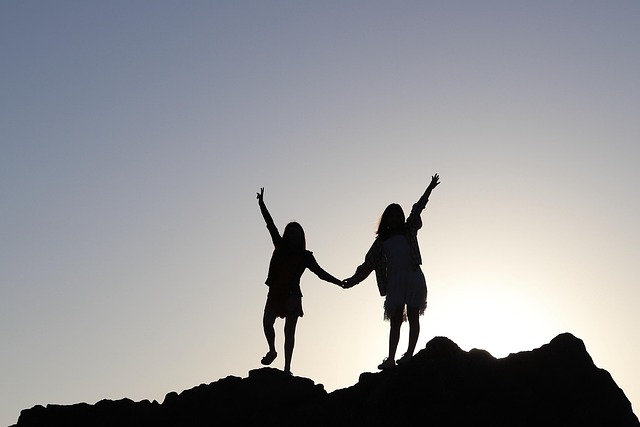 two people holding hands on a mountain